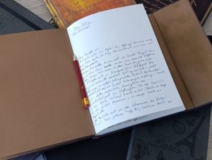 Open notebook with handwritten notes about storytelling and a pencil